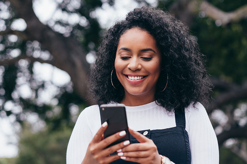 Woman using Zelle on a mobile phone